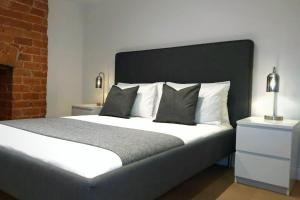 1 dormitorio con 1 cama grande y pared de ladrillo en Stylish Apartment in City Centre with Parking en Preston