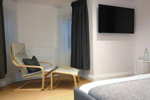 a bedroom with two chairs and a television on a wall at Stylish Apartment in City Centre with Parking in Preston
