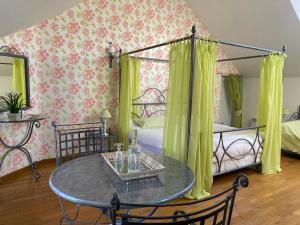 Cette chambre comprend une table, un lit, une table et des chaises. dans l'établissement La Closerie des Sacres, à Lavannes