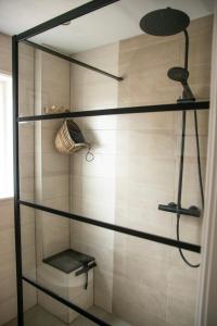 W łazience znajduje się kabina prysznicowa ze szklanymi półkami. w obiekcie huisje de Strandjutter w mieście Katwijk aan Zee