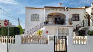 una casa blanca con una valla blanca en Hello Oliva Beach BB, en Oliva