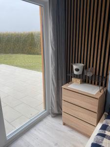 sypialnia z przesuwnymi szklanymi drzwiami prowadzącymi na patio w obiekcie Komfortowy Domek Natura, w pobliżu Nadmorskiego Parku Krajobrazowego, 800 m od plaży w mieście Karwieńskie Błoto Drugie