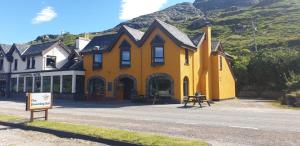 a yellow building on the side of a road at The Dundonnell Hotel in Dundonnell