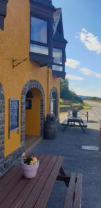 a building with a picnic table and a bench outside at The Dundonnell Hotel in Dundonnell