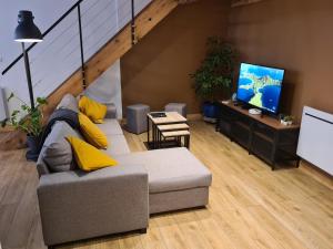 a living room with a couch and a flat screen tv at "COMME A LA MAISON" - 2 Apparts neuf tout confort - 3 chambres 100m2 ou 2 chambres 50m2 in Rambervillers