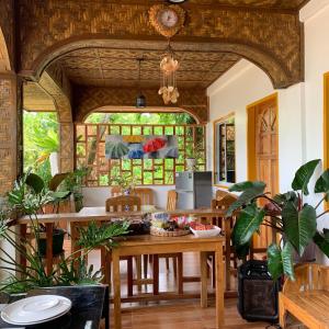a dining room with a table and some plants at Domos Native Guest House in Panglao