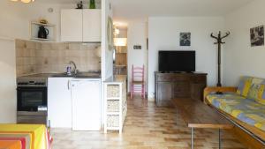 kuchnia i salon z białą lodówką i kanapą w obiekcie Eleuthera- 174- Appart en rez de jardin- 4pers w Cap d'Agde +6 zdjęć