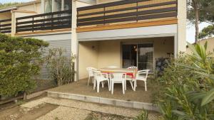 stół i krzesła na ganku domu w obiekcie Eleuthera- 174- Appart en rez de jardin- 4pers w Cap d'Agde