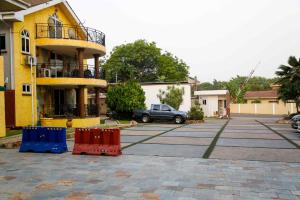 een auto geparkeerd op een parkeerplaats naast een gebouw bij Midindi Hotel in Accra