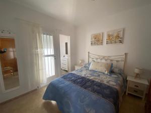 a bedroom with a bed with a blue blanket at Casa Rural El Jazminero in Fernán Pérez