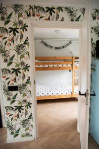 huisje de Strandjutter في Katwijk aan Zee: غرفة مع سرير بطابقين وجدار مغطى بورق الجدران