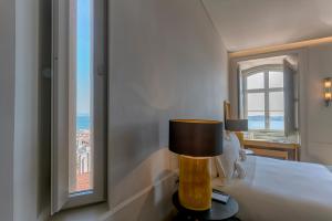 a hotel room with a bed and a window at Verride Palácio Santa Catarina in Lisbon