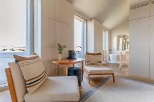 ein Wohnzimmer mit 2 Stühlen und einem Tisch in der Unterkunft Verride Palácio Santa Catarina in Lissabon
