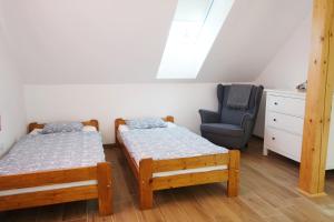 a bedroom with two twin beds and a chair at Chalupa Luční Kvítí in Petrovice u Susice