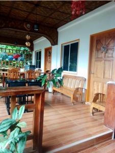 ein Restaurant mit Holztischen und -stühlen und Holzboden in der Unterkunft Domos Native Guest House in Panglao