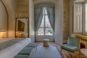 a bedroom with a bed and a large window at Verride Palácio Santa Catarina in Lisbon +123 photos