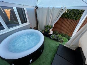 a hot tub sitting on the grass in a backyard at The Cave House Canterbury with Hot Tub in Kent
