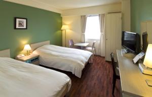 En eller flere senge i et værelse på Hotel Granview Ishigaki