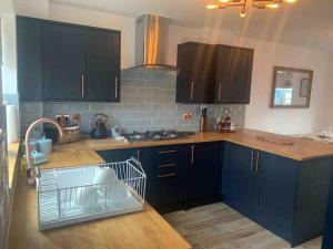 a kitchen with black cabinets and a counter top at Holly Tree Cottage in Barmby on the Moor