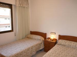 a hotel room with two beds and a window at PLAYAMAR ORANGE COSTA 3 dormitorios in Alcossebre