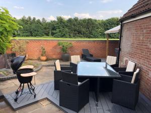 a patio with a table and chairs on a deck at Holly Tree Cottage in Barmby on the Moor