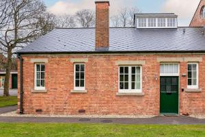 uma casa de tijolos vermelhos com uma porta verde em Betts (Private Ensuite room) at Bicester Heritage em Bicester