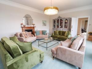 een woonkamer met banken en een kroonluchter bij The Downwood in Blandford Forum