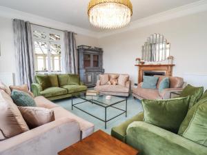 a living room with couches and a chandelier at The Downwood in Blandford Forum