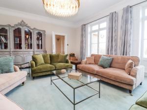 a living room with two couches and a chandelier at The Downwood in Blandford Forum