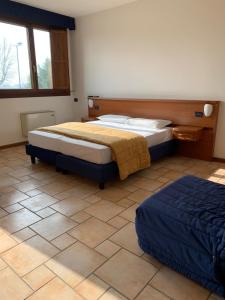 a bedroom with two beds and a tiled floor at Hotel Lory Ficarolo in Ficarolo