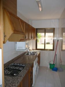 a kitchen with a sink and a stove top oven at PLAYAMAR ORANGECOSTA 1 dormitorio in Alcossebre