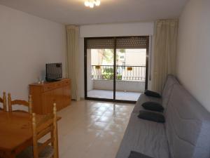 a living room with a couch and a sliding glass door at PLAYAMAR ORANGECOSTA 1 dormitorio in Alcossebre