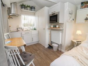 a small room with a table and a kitchen at Art Studio in Blandford Forum