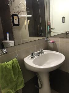 y baño con lavabo blanco y espejo. en Departamento Mendoza Olascoaga 2 en Mendoza
