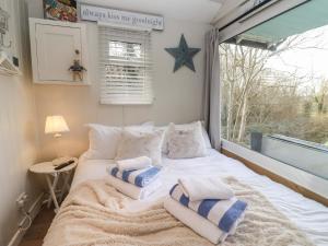 a bedroom with a bed with pillows and a window at Art Studio in Blandford Forum