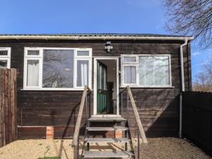 a tiny house with a green door and stairs at Dreamwood in Blandford Forum
