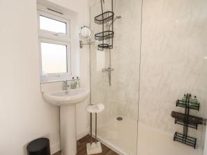 a white bathroom with a sink and a shower at Dreamwood in Blandford Forum