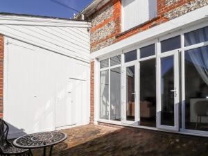 a patio with a sliding glass door and a table at Primrose in Blandford Forum