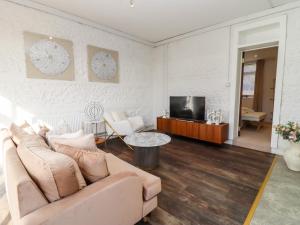 a living room with a couch and a tv at Primrose in Blandford Forum