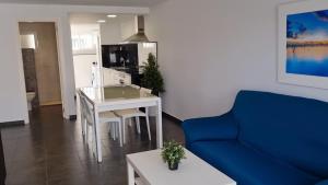 sala de estar con mesa blanca y sofá azul en HELLO OLIVA BEACH Bungalow Bajo, en Oliva