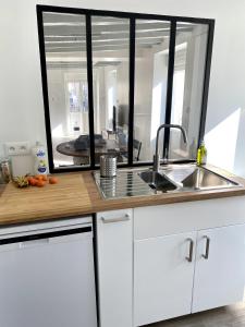 - une cuisine avec un évier et un miroir dans l'établissement Le Chill Loft, à Miramont-de-Guyenne