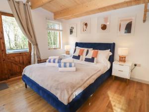 a bedroom with a blue bed with pillows on it at Copper Beach in Blandford Forum