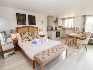 a bedroom with a large bed and a kitchen at Meadow in Blandford Forum