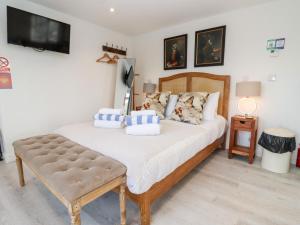 a bedroom with a bed and a table and a tv at Meadow in Blandford Forum