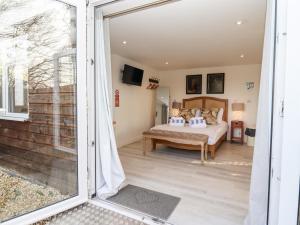 1 dormitorio con 1 cama y puerta corredera de cristal en Meadow, en Blandford Forum