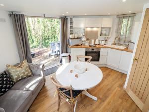a kitchen and living room with a table and a couch at Honeycombe in Blandford Forum