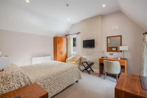 a bedroom with a bed and a desk with a computer at Castle Of Comfort Hotel in Nether Stowey