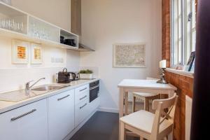 cocina blanca con fregadero y mesa en Rotheram (Suite) at Bicester Heritage en Bicester