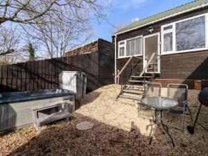 a backyard with a barbecue and a house at Stillness in Blandford Forum