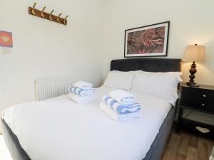 a bedroom with a white bed with towels on it at Stillness in Blandford Forum